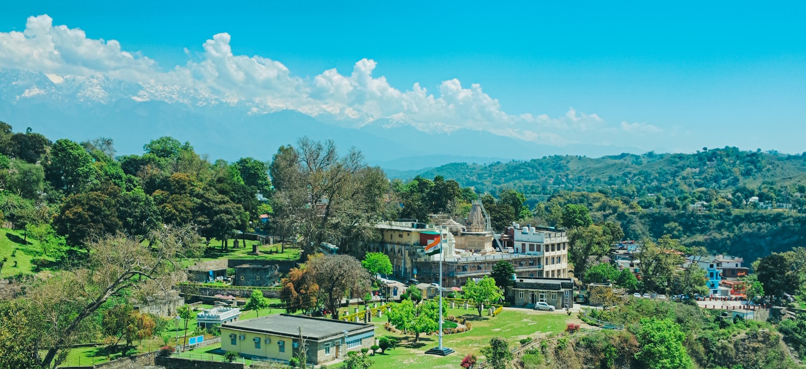 An aerial view of Kangra town surrounded by trees.