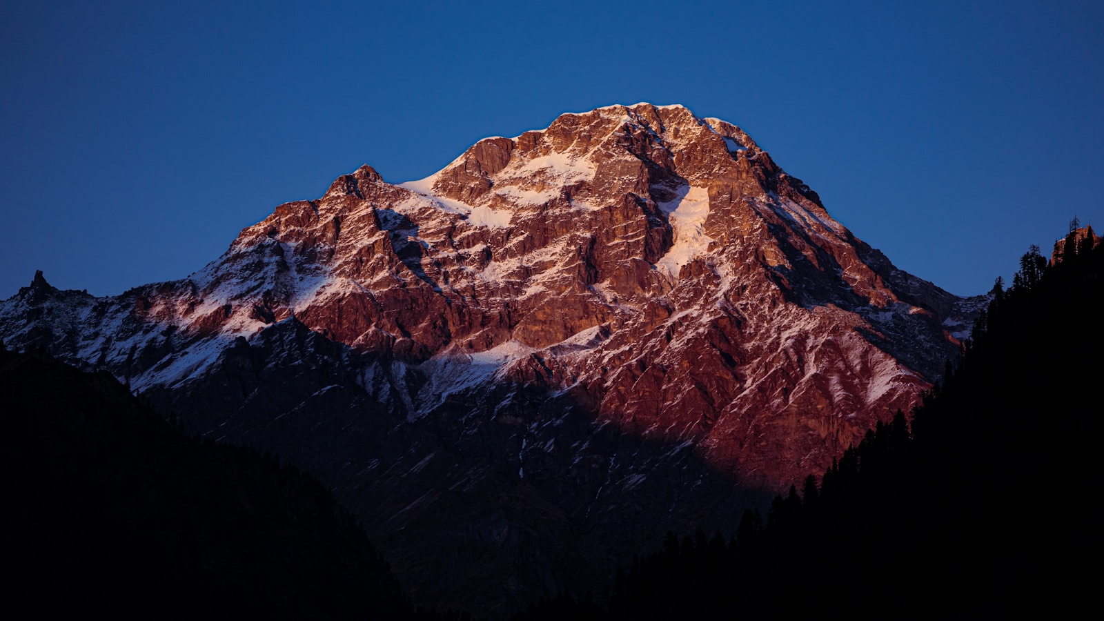 A snow-covered Himalayan peak at sunset.